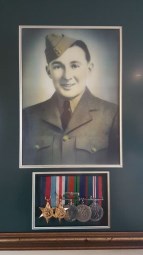 Picture of Young Leonard Robinet in a frame with medals