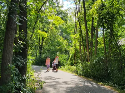People walking down Brunet Park Loop with a stroller.