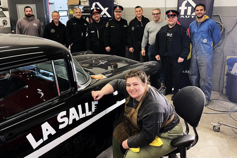Person painting letters on black car