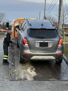 grey suv being loaded onto a flatbed towtruck