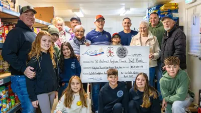 A group of people standing holding a cheque.