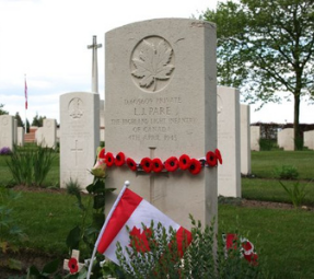 Headstone wrapped in poppies for Leon Paré