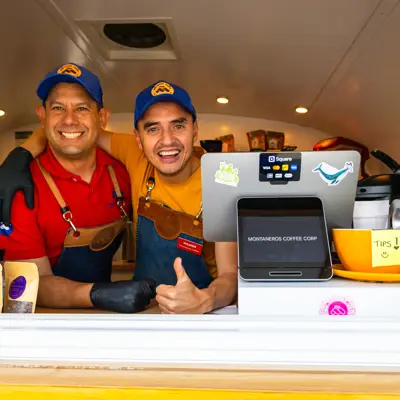 Two people smiling in a food truck.