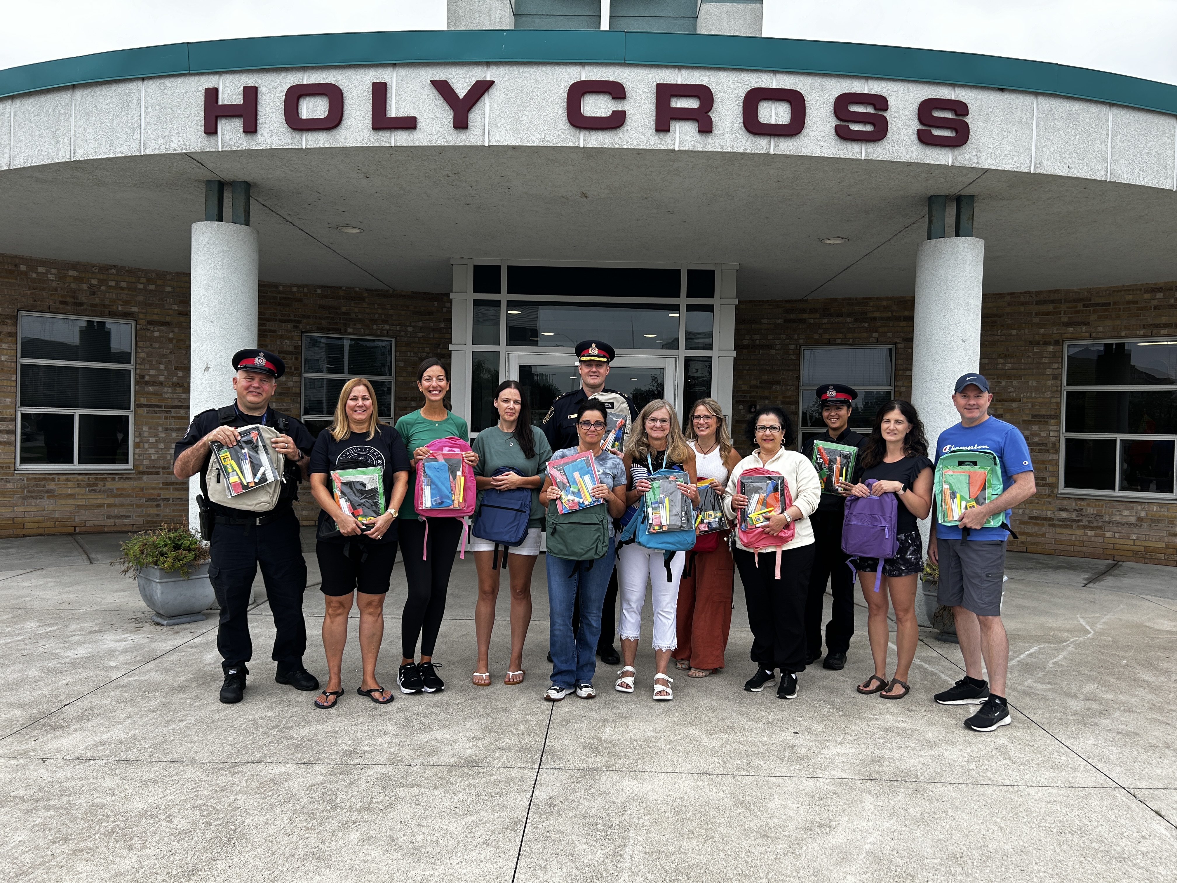 People holding up back packs