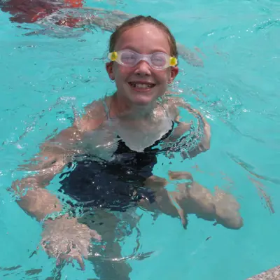 Child smiling in a pool.