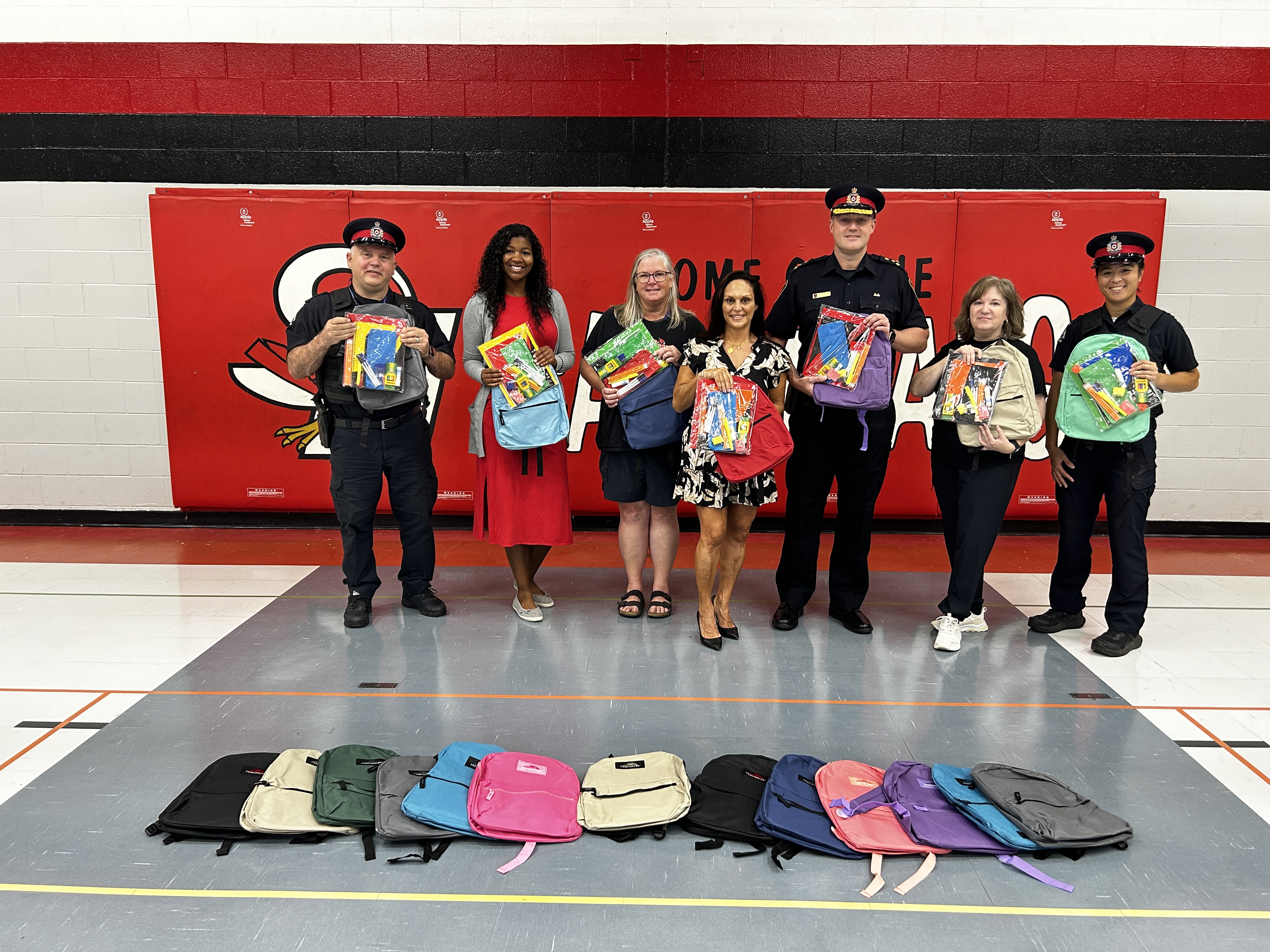 People holding up back packs