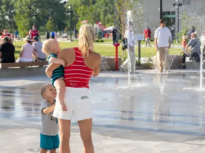 Family standing near a water fountain.