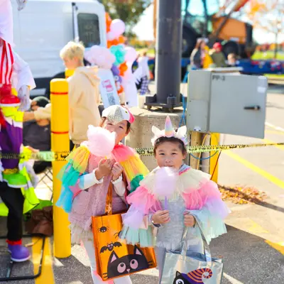 Children in costumes eating cotton candy.