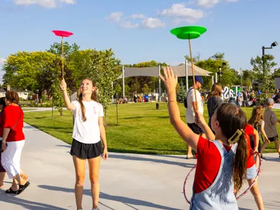 Children balancing frisbees on sticks.
