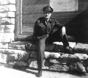 Young Ralph Munholland sitting down on a brick wall in uniform