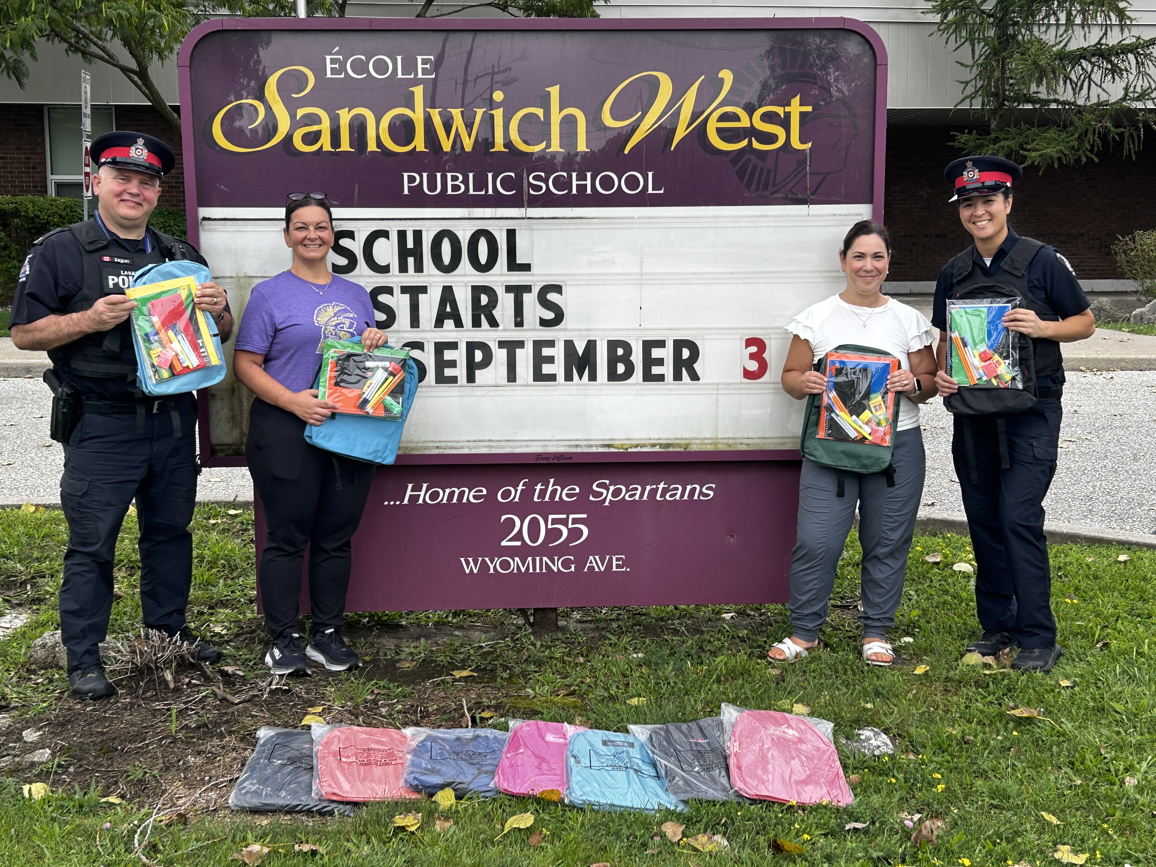 People holding up back packs