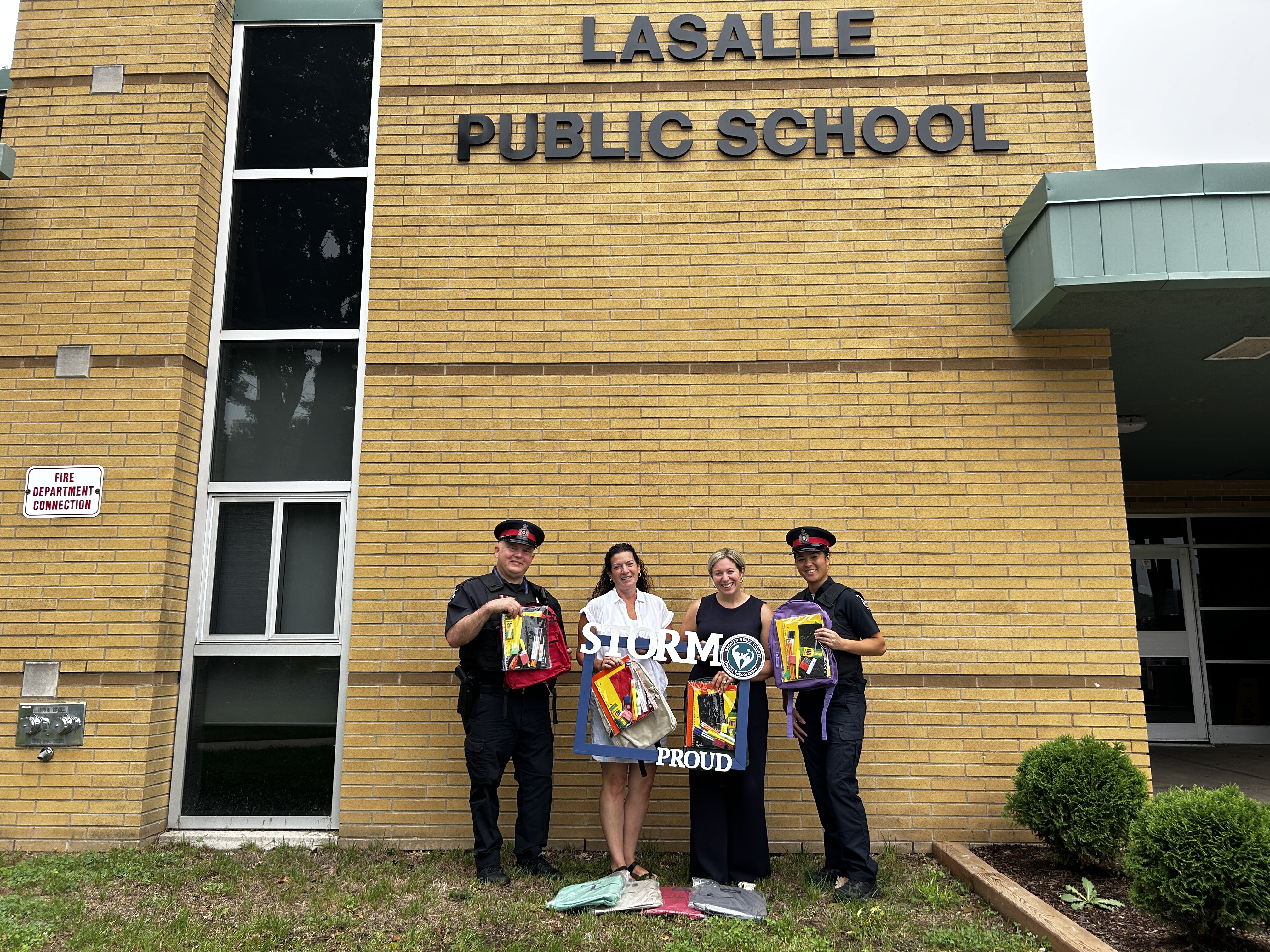 People holding up back packs