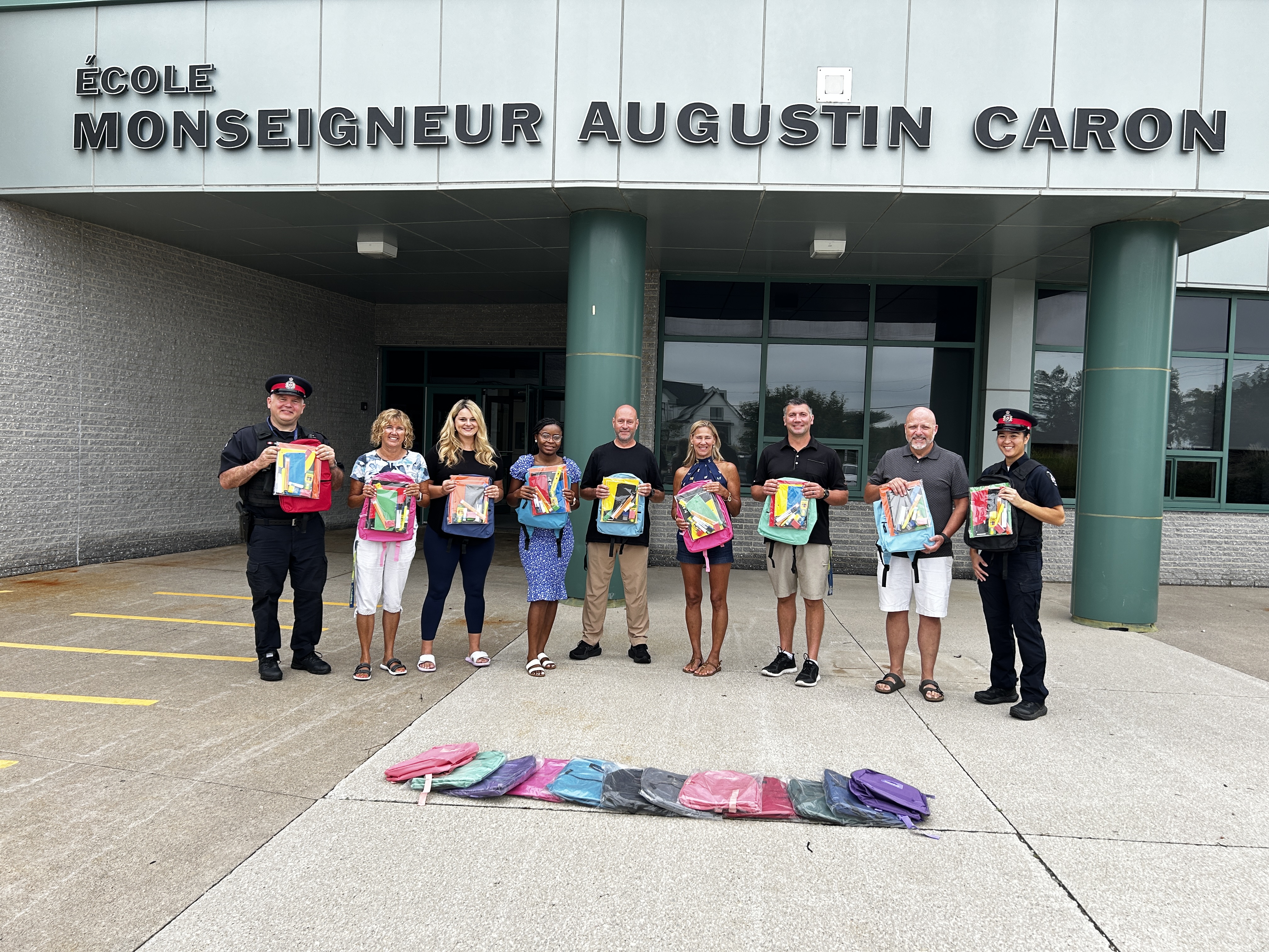 People holding up back packs