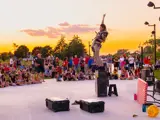 Performer standing in front of an outdoor crowd.