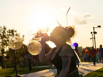 Person blowing bubbles outside.