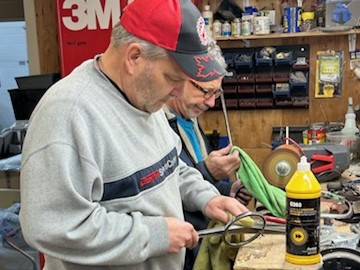 two men polishing metal